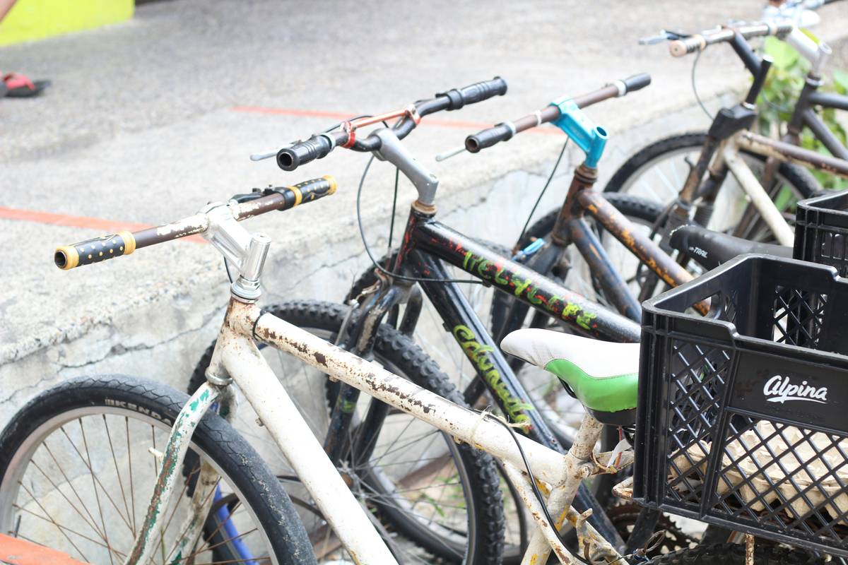 Mountain Bike Rental Services: technician inspecting an ebike motor and battery mount on a rugged trailside workstation